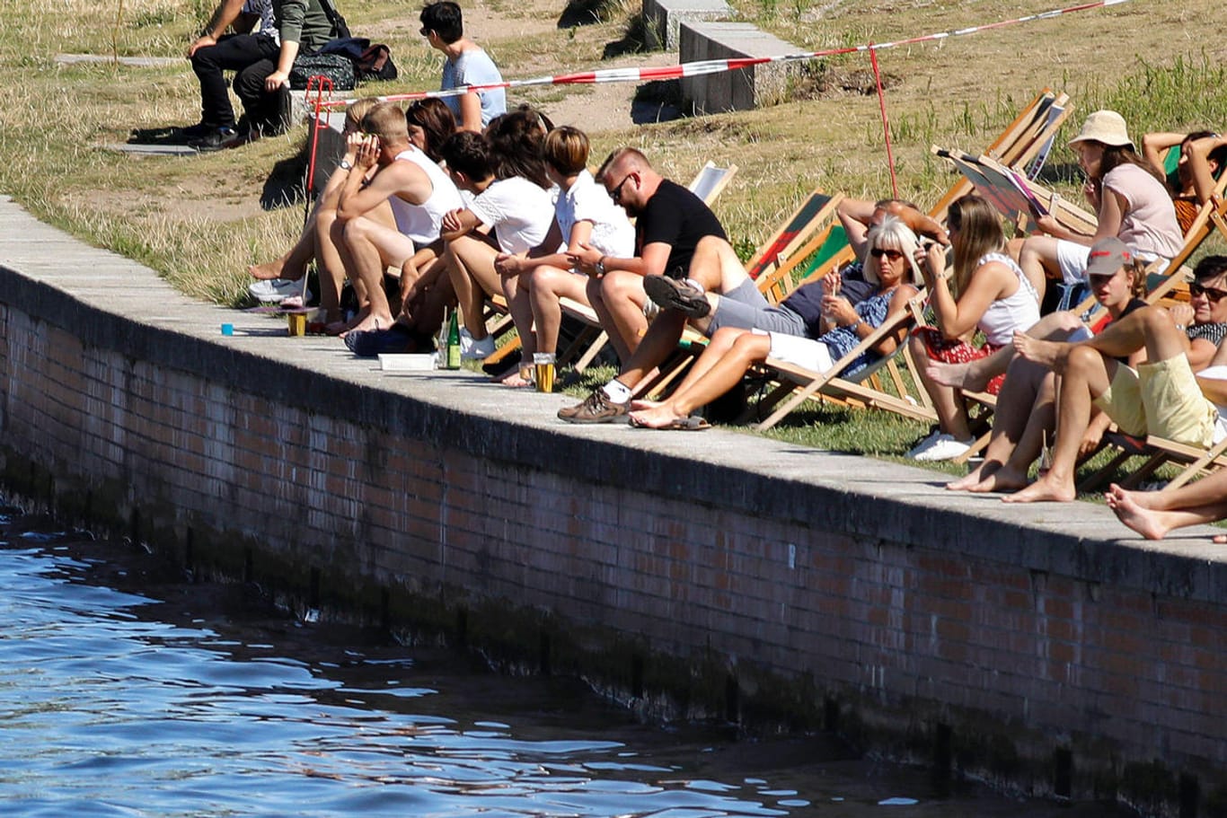 Menschen genießen am Spreeufer in Berlin die Sonne (Archivbild): Experten warnen in diesem Jahr vor einer möglichen Coronawelle im Sommer.