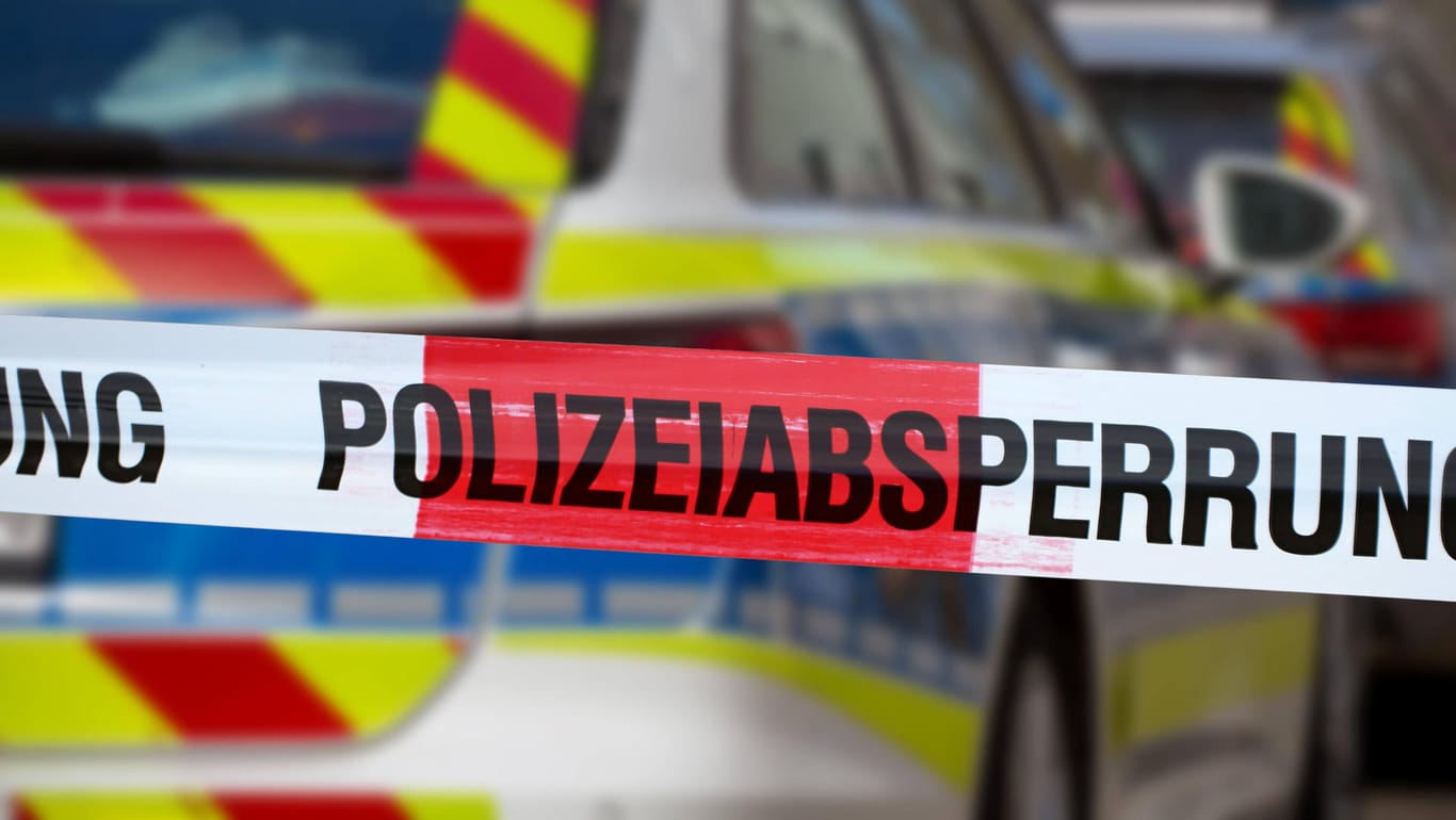 Eine Absperrung vor einem Polizeiauto (Symbolfoto): In Köln-Mülheim ist ein Mann leblos im Innenhof einen Hauses aufgefunden worden.