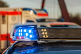 Ein Einsatzfahrzeug der Polizei setht mit Blaulicht, im Hintergrund ist ein Rettungswagen (Symbolfoto): Ein Mann ist südlich von Berlin mit einem Lkw gegen einen Brückenpfeiler gefahren und dabei tödlich verletzt worden.
