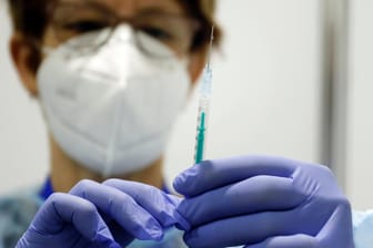 Eine Fachkraft zieht eine Spritze mit Impfstoff auf (Symbolbild): Langsam gehen die Infektionszahlen in Deutschland zurück.