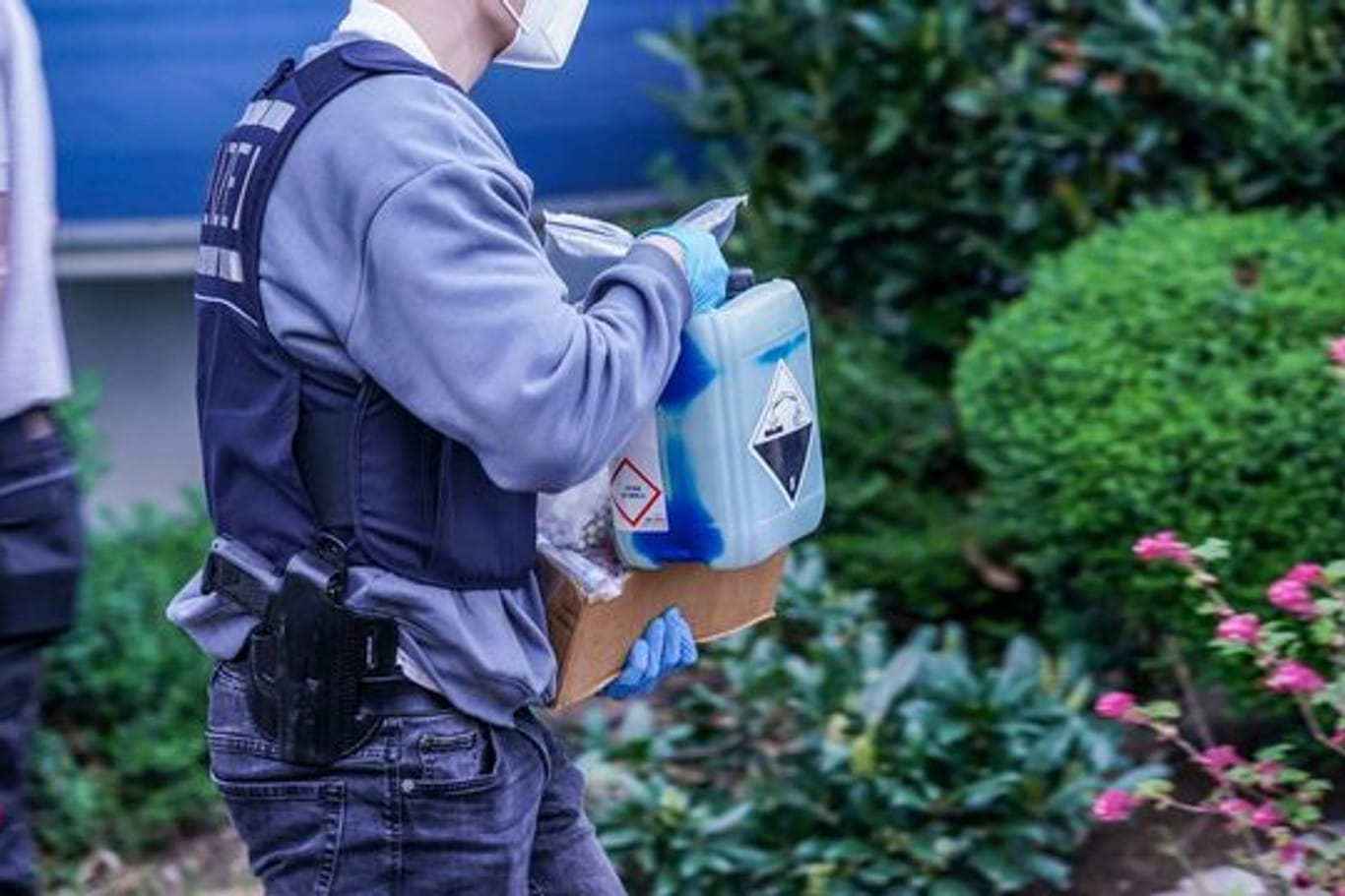 Ein Polizist trägt Chemikalien aus dem Wohnhaus eines Verdächtigen (Archivbild): Noch ist unklar, was er damit vorhatte.