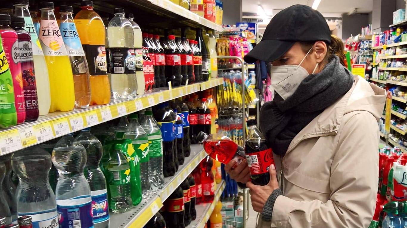 Eine Frau mit Maske vor einem Supermarktregal (Symbolbild): Das RKI rät für die Osterfeiertage zu Vorsichtsmaßnahmen.