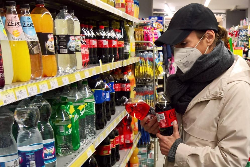 Eine Frau mit Maske vor einem Supermarktregal (Symbolbild): Das RKI rät für die Osterfeiertage zu Vorsichtsmaßnahmen.