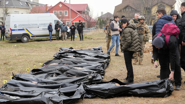 Butscha: Iryna Wenediktowa (mit Mütze), die Generalstaatsanwältin der Ukraine, betrachtet exhumierte Leichen aus einem Massengrab.