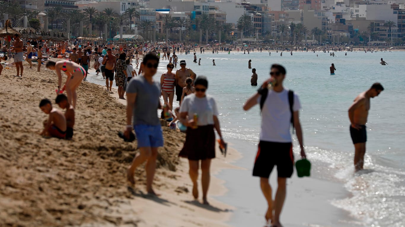 Touristen laufen am Strand von Arenal, Palma (Symbolbild): Der Tourismus ist ein entscheidender Wirtschaftsfaktor auf Mallorca.