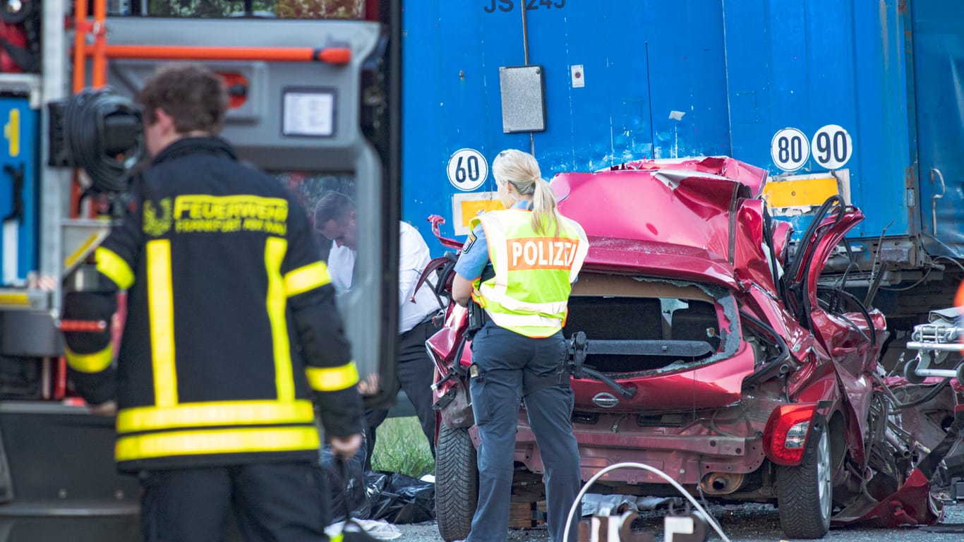 Rettungskräfte neben dem völlig zerstörten Unfallwagen: Der Fahrer erlitt schwerste Verletzungen.
