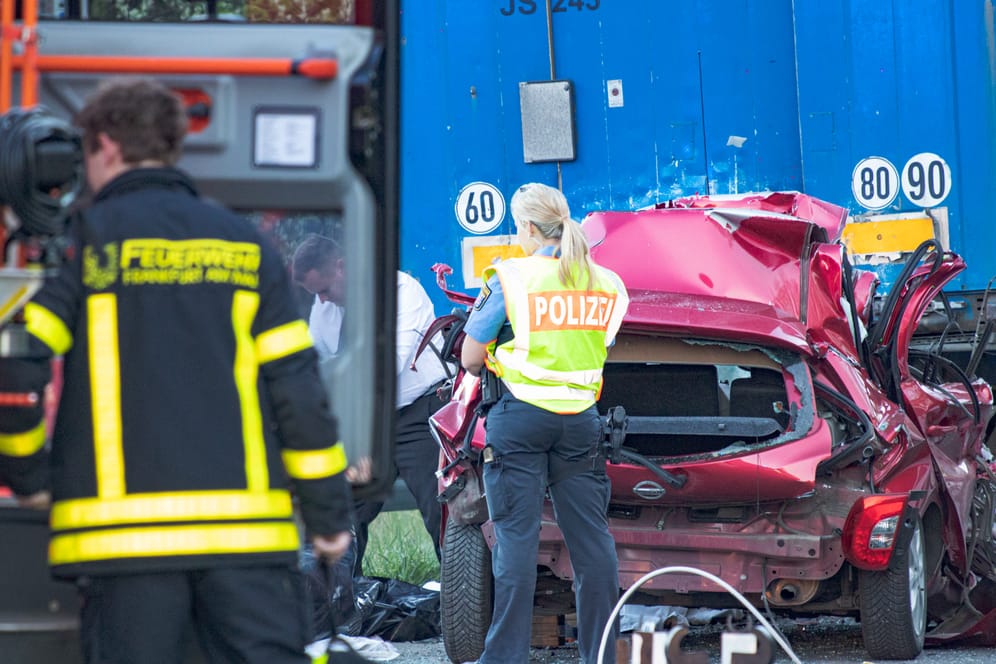 Rettungskräfte neben dem völlig zerstörten Unfallwagen: Der Fahrer erlitt schwerste Verletzungen.