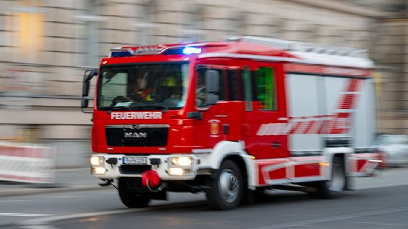 Ein Feuerwehrfahrzeug ist mit Blaulicht auf Einsatzfahrt (Symbolbild): Eine Person musste in ein Krankenhaus gebracht werden.