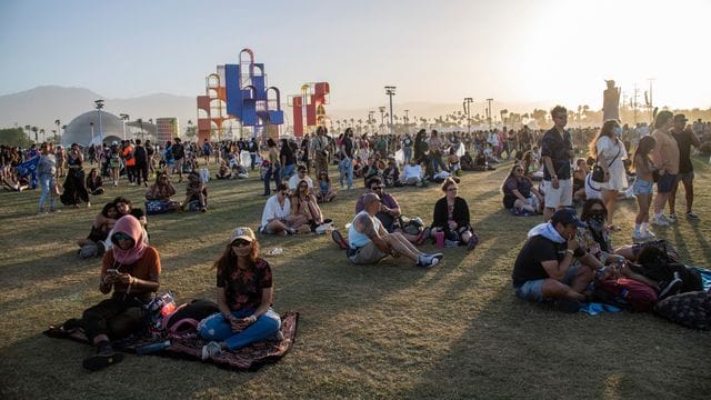 Festivalbesucher sitzen auf dem Gelände des Coachella-Festivals 2022.