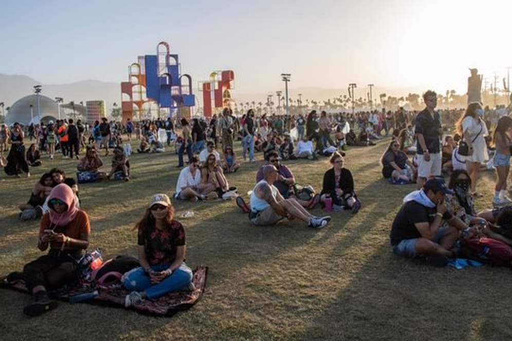 Festivalbesucher sitzen auf dem Gelände des Coachella-Festivals 2022.