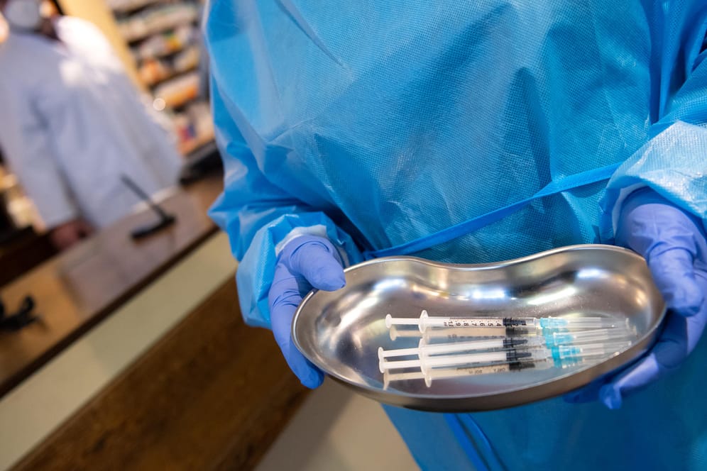 Eine Krankenpflegerin steht mit Spritzen in einer Schale in einer Apotheke (Symbolbild): Noch sind weitere Auffrischungsimpfungen in Deutschland nötig.