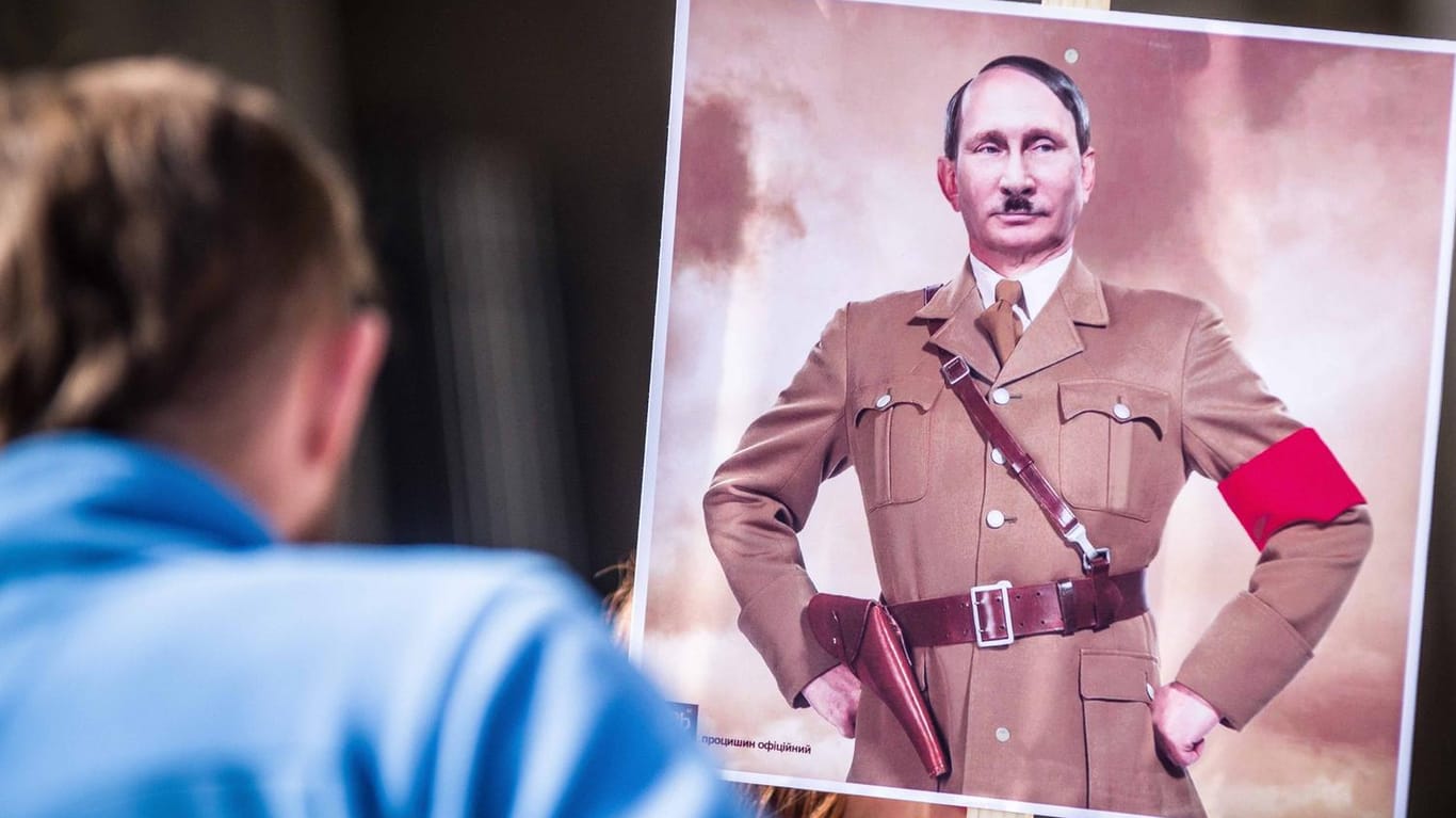 Auf Antikriegs-Demos wie hier in München wird Wladimir Putin nicht selten als Hitler dargestellt.