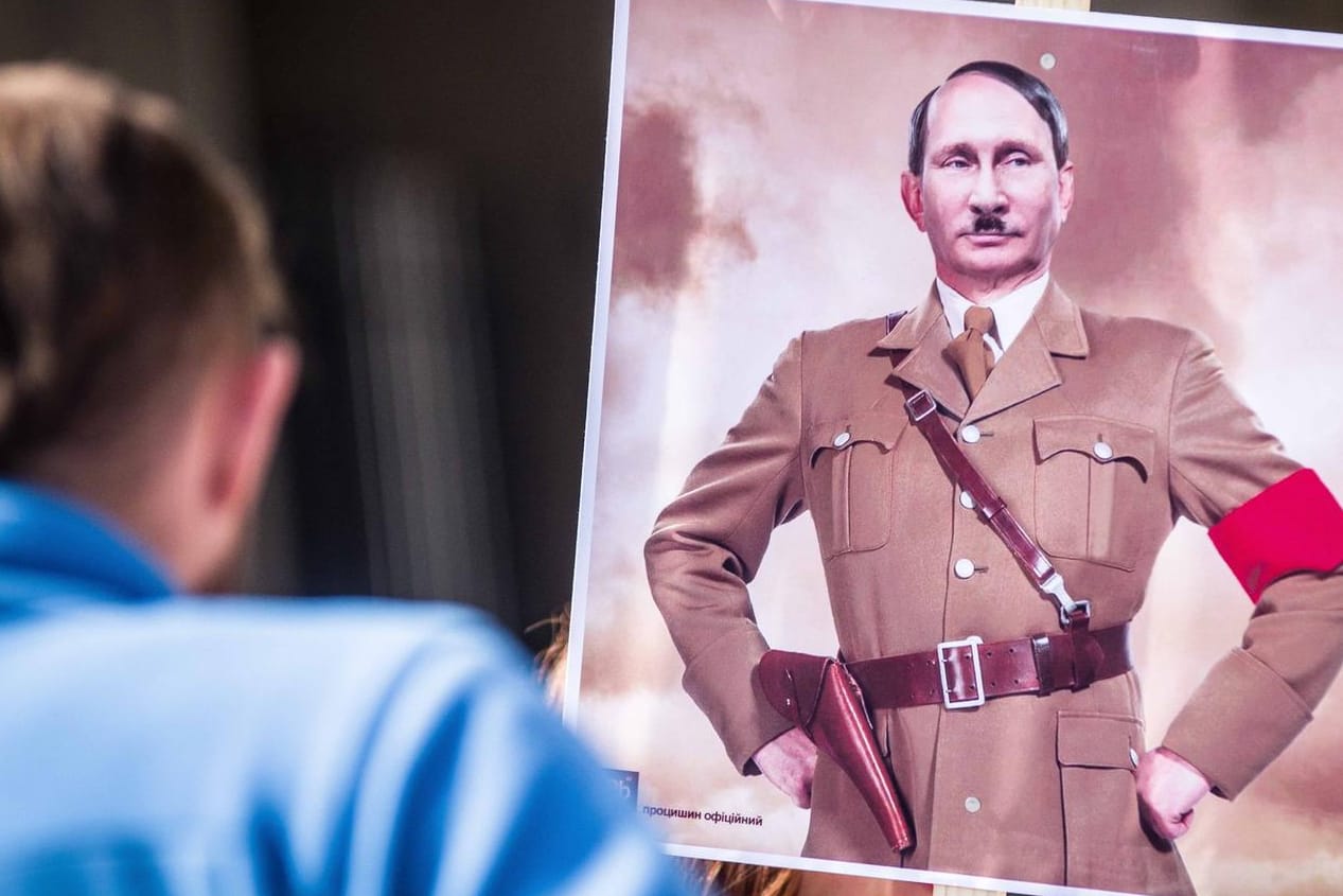 Auf Antikriegs-Demos wie hier in München wird Wladimir Putin nicht selten als Hitler dargestellt.