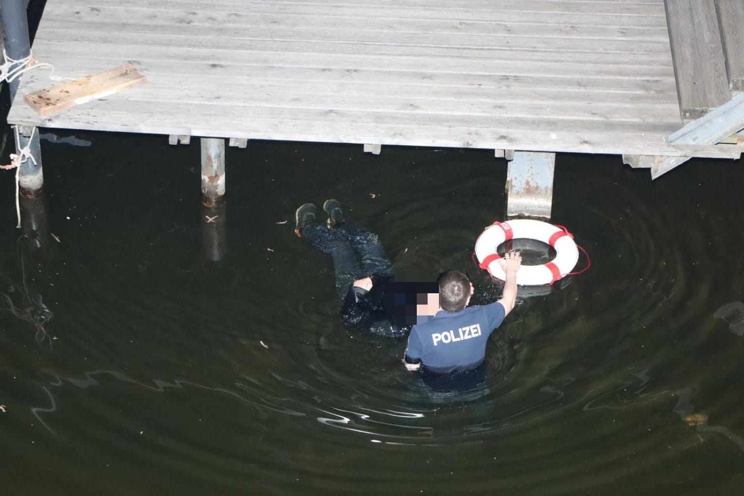 Ein Polizeimeister bei der hilflosen Person: Der Beamte hat dem Mann wohl das Leben gerettet.