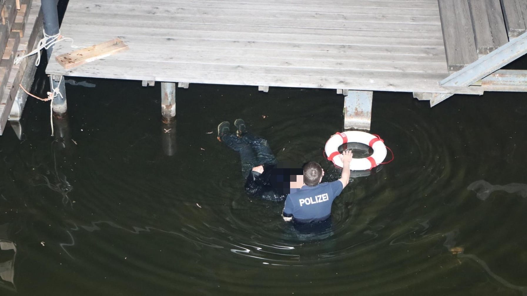 Ein Polizeimeister bei der hilflosen Person: Der Beamte hat dem Mann wohl das Leben gerettet.