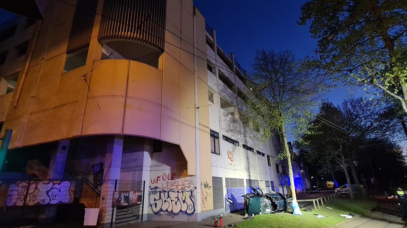 Das Wrack eines Autos liegt neben einem Parkhaus: Zwei junge Männer sind am Ostersonntag in Essen mit einem Auto aus der obersten Etage eines Parkhauses gestürzt und ums Leben gekommen.