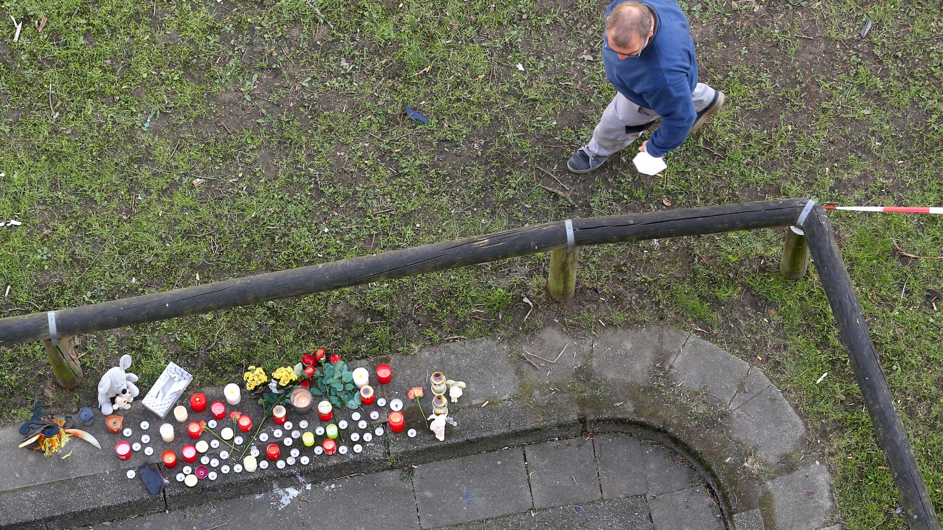 Ein Arbeiter schaut sich am Parkhaus die Trauerstelle an: Es steht nach Angaben der Polizei aus der Nacht der Verdacht im Raum, dass der Wagen auf dem Parkdeck für Fahrmanöver genutzt wurde - und deshalb durch ein Geländer schoss.