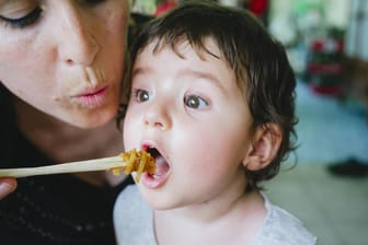 Eine Mutter füttert ihr Kind im Restaurant (Symbol): Ein Lokal an der Ostsee bewirtet keine Familien mit kleinen Kindern mehr.