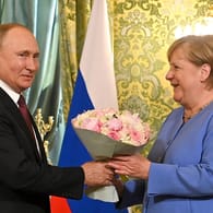 Zum Abschied Blumen: Angela Merkel 2021 bei ihrem letzten Besuch als Bundeskanzlerin in Moskau.