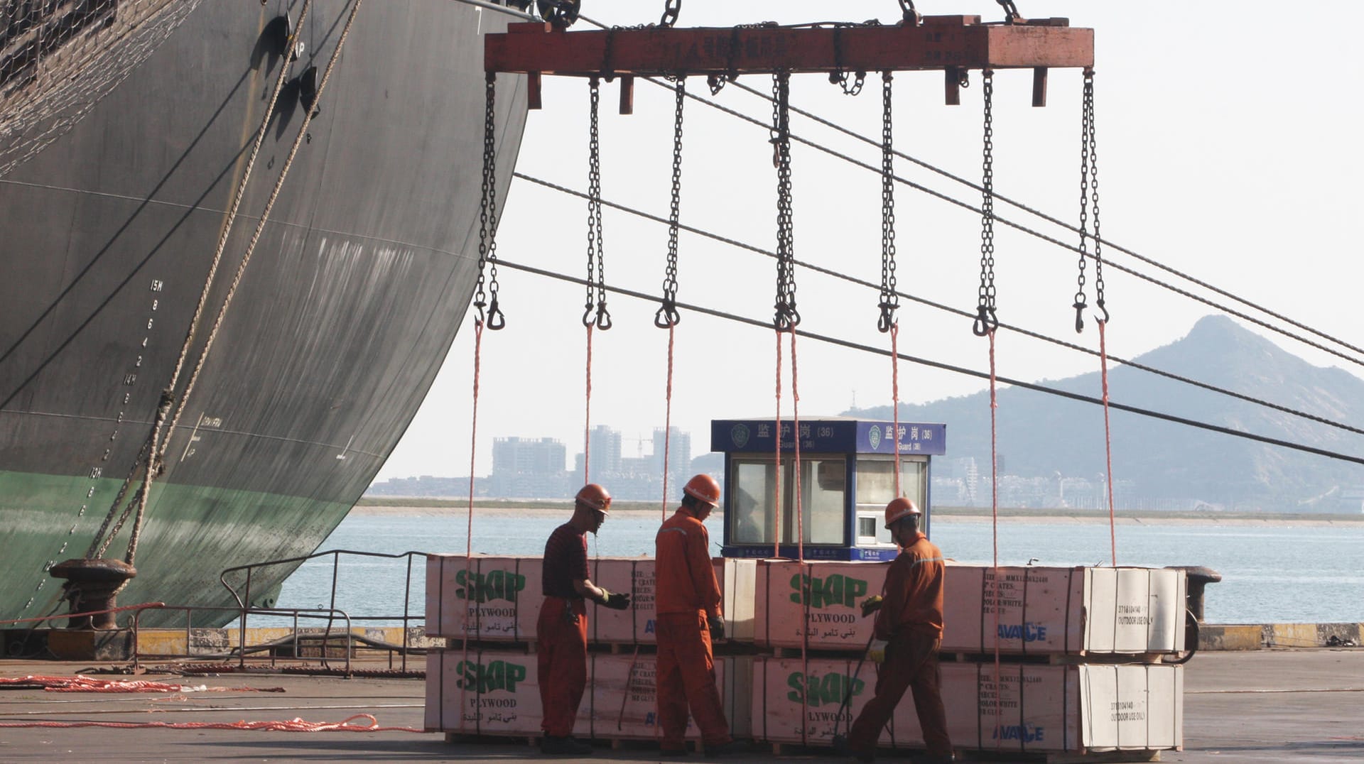 Hafenmitarbeiter beim Verladen (Symbolbild): Der harte Lockdown in China könnte sich noch stark auf die Weltwirtschaft auswirken.