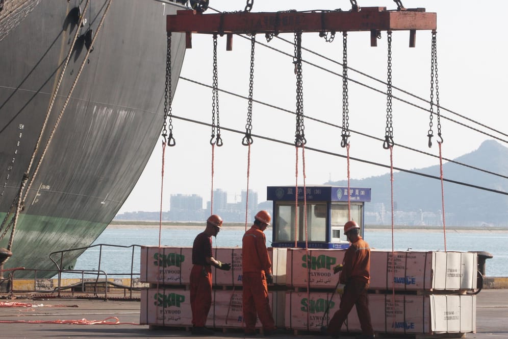 Hafenmitarbeiter beim Verladen (Symbolbild): Der harte Lockdown in China könnte sich noch stark auf die Weltwirtschaft auswirken.