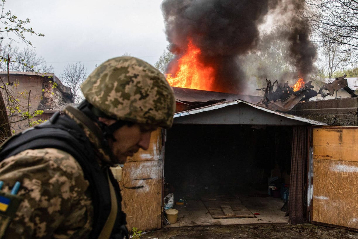 Ein ukrainischer Soldat vor einem brennenden Gebäude in Kharkiv: Damit habe die "zweite Phase des Krieges" begonnen.