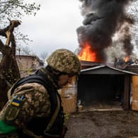 Ein ukrainischer Soldat vor einem brennenden Gebäude in Kharkiv: Damit habe die "zweite Phase des Krieges" begonnen.