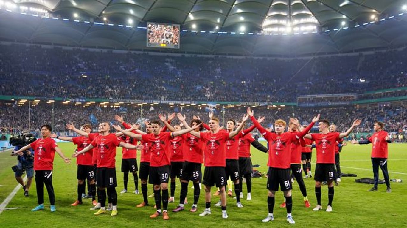 Die Spieler vom SC Freiburg feiern mit den Fans den Einzug ins Pokalfinale.