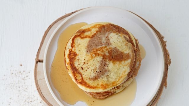 Die zweifarbigen Pancakes werden mit Ahornsirup und Butter serviert.