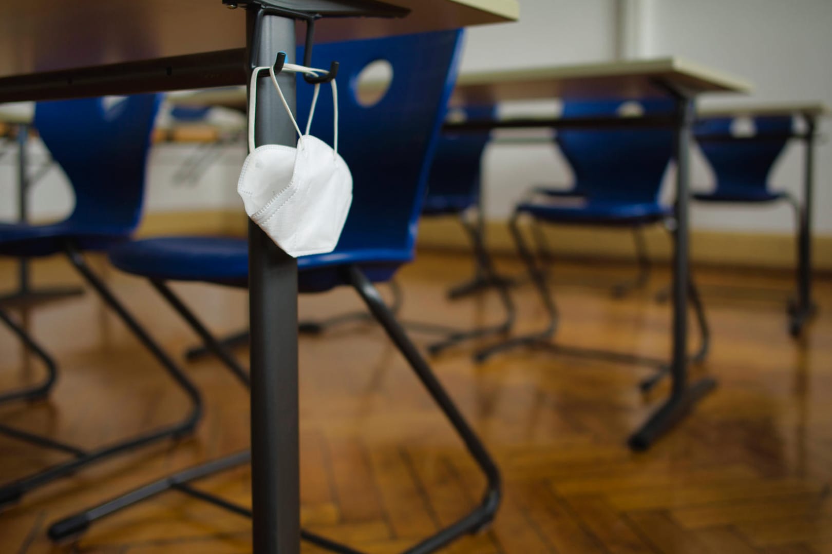 Eine FFP2-Maske hängt an einer Schulbank (Symbolbild): Nach Ostern soll die Maskenpflicht an Niedersachsens Schulen fallen.