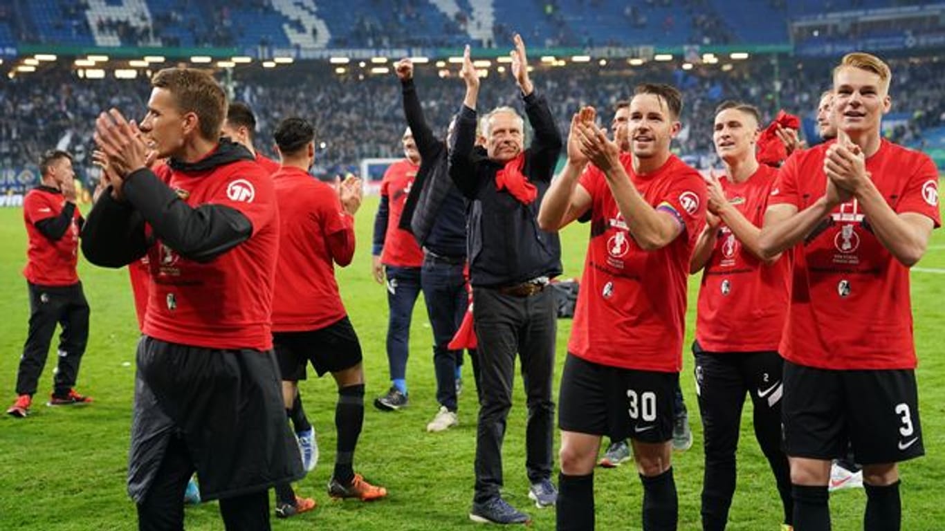Die Spieler des SC Freiburg freuen sich mit Trainer Christian Streich (M) über den Einzug ins Finale des DFB-Pokals.