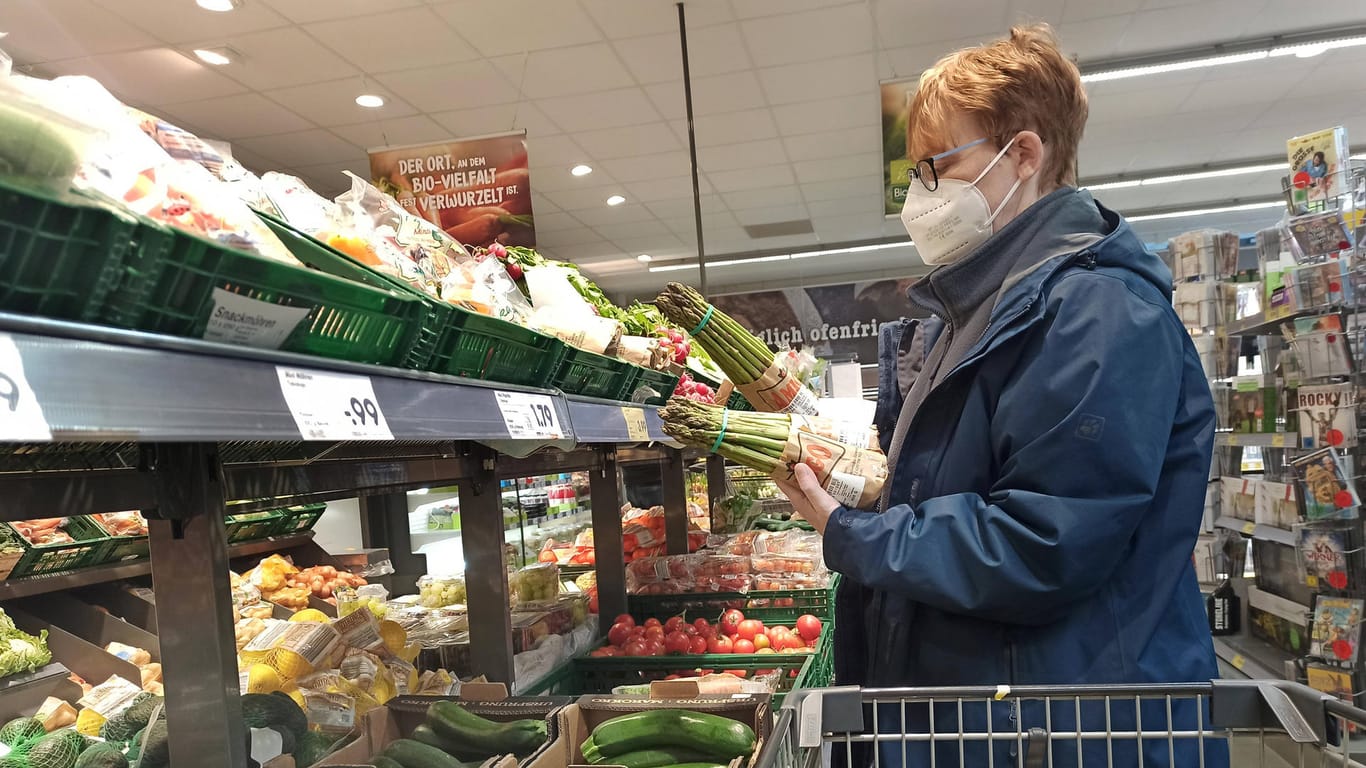 Eine Frau hält zwei Pakete Spargel in den Händen (Symbolbild): Die Produkte aus dem Ausland sorgen für hohen Preisdruck bei den Bauern.
