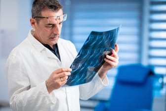 Ein Arzt betrachtet eine MRT-Aufnahme der Wirbelsäule