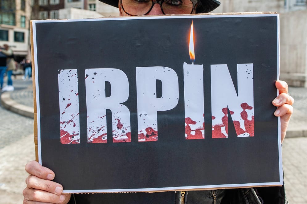 Eine Person hält ein Schild mit der Aufschrift "Irpin" (Archivbild): Der Vorort Kiews ist zum Symbol für russische Kriegsverbrechen geworden.
