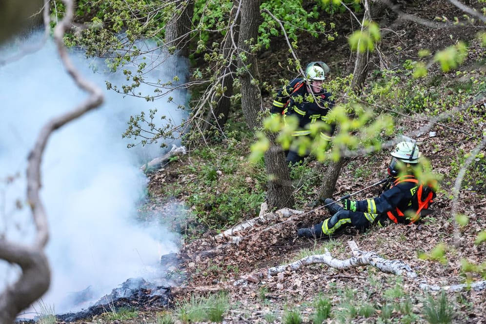 Einsatzkräfte der Feuerwehr löschen unter schweren Bedingungen am Mittwochabend einen Waldbrand an einem Hang: Stundenlang kämpften 80 Kräfte gegen die Flammen.