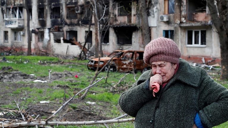 Eine 71-jährige Bewohnerin Mariupols weint vor einem zerstörten Gebäude.