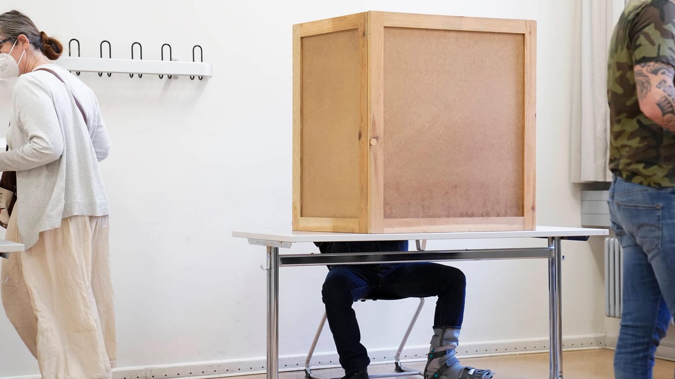 Eine Person in einer Wahlkabine (Archivbild): Bislang sind nur Menschen ab 18 Jahren bei den Berliner Landtagswahlen wahlberechtigt.