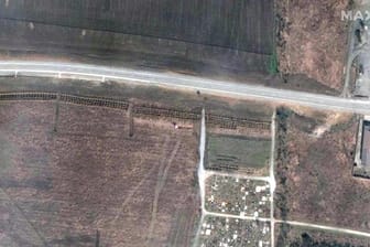 Dieses Satellitenbild soll ein Massengrab parallel zum Straßenverlauf in Manhusch, etwa 20 Kilometer westlich von Mariupol, zeigen.