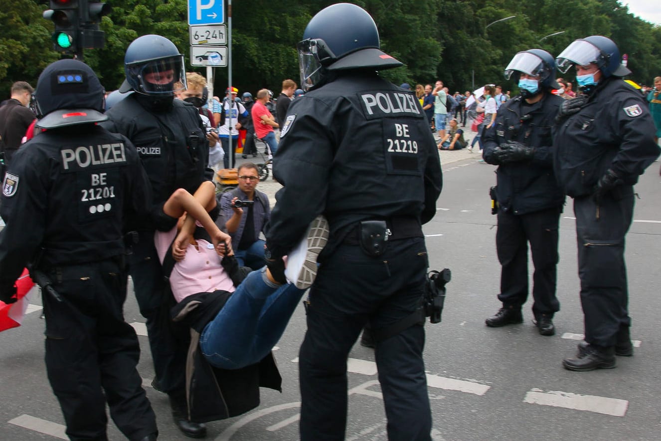 Polizisten tragen eine Demonstrantin weg (Archivbild): Videos von Polizeieinsätzen bei Corona-Demonstrationen waren die Veranlassung für die Anfrage bei der Bundesregierung.