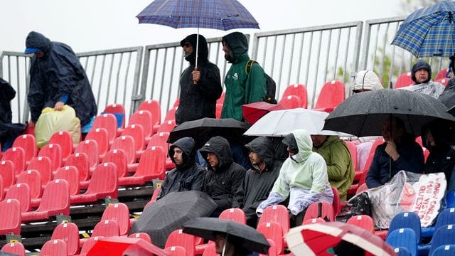 Fans sitzen während des Freien Trainings mit Regenschirmen auf der Tribüne. Fans sitzen während des Freien Trainings mit Regenschirmen auf der Tribüne.