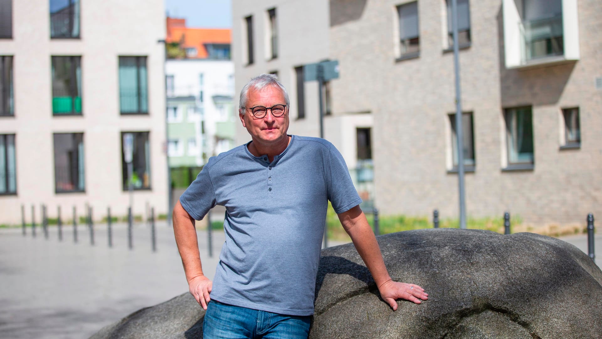 Geologe Sven von Loga auf dem Platz der Kinderrechte: Der Findling in der Mitte des Platzes stammt aus dem eiszeitlichen Skandinavien.