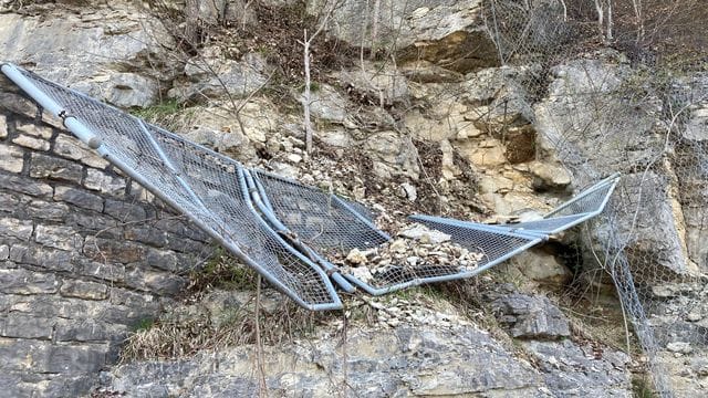 Ein durch kleinere Felsstürze beschädigtes Gitter hängt an dem Felsen über der Autobahn: Ab 16 Uhr ist die A8 Richtung Stuttgart wieder freigegeben. Ein durch kleinere Felsstürze beschädigtes Gitter hängt an dem Felsen über der Autobahn: Ab 16 Uhr ist die A8 Richtung Stuttgart wieder freigegeben.