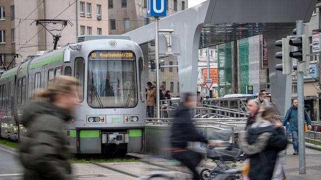 Menschen laufen an einer Stadtbahn vorbei (Symbolbild): Ein Unbekannter wollte von außen an der Bahn mitfahren.