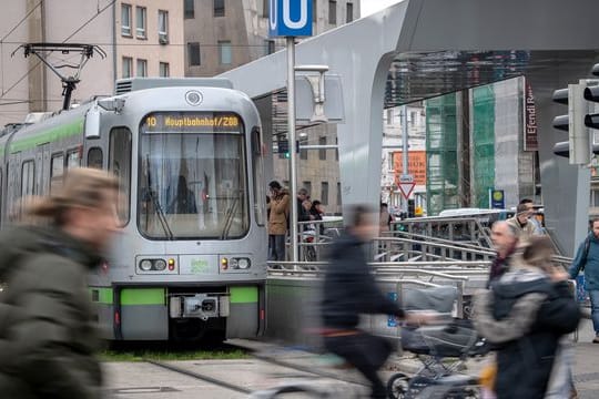 Menschen laufen an einer Stadtbahn vorbei (Symbolbild): Ein Unbekannter wollte von außen an der Bahn mitfahren.