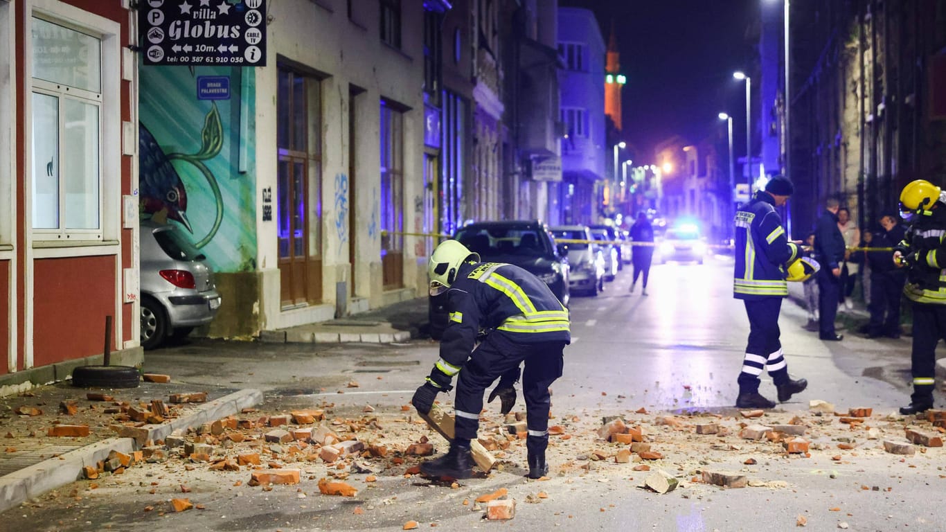 Einsatzkräfte der Feuerwehr räumen Schutt von der Straße: In der Nähe von Mostar wurden mehrere Häuser beschädigt, eine Frau starb.