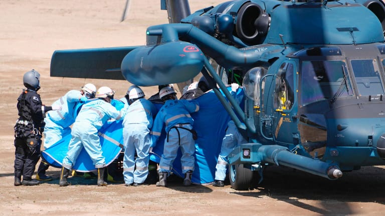 Rettungskräfte transportieren eine gerettete Person aus einem Hubschrauber auf der Insel Hokkaido: Mindestens zehn Menschen sind bei dem Schiffsunglück ums Leben gekommen.