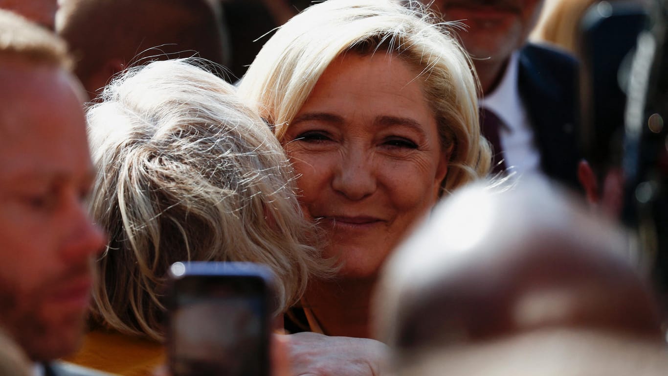 Marine Le Pen umarmt eine Bürgerin: Mit ihren Fans ist die Rechtspopulistin kurz vor der Wahl auf Kuschelkurs.