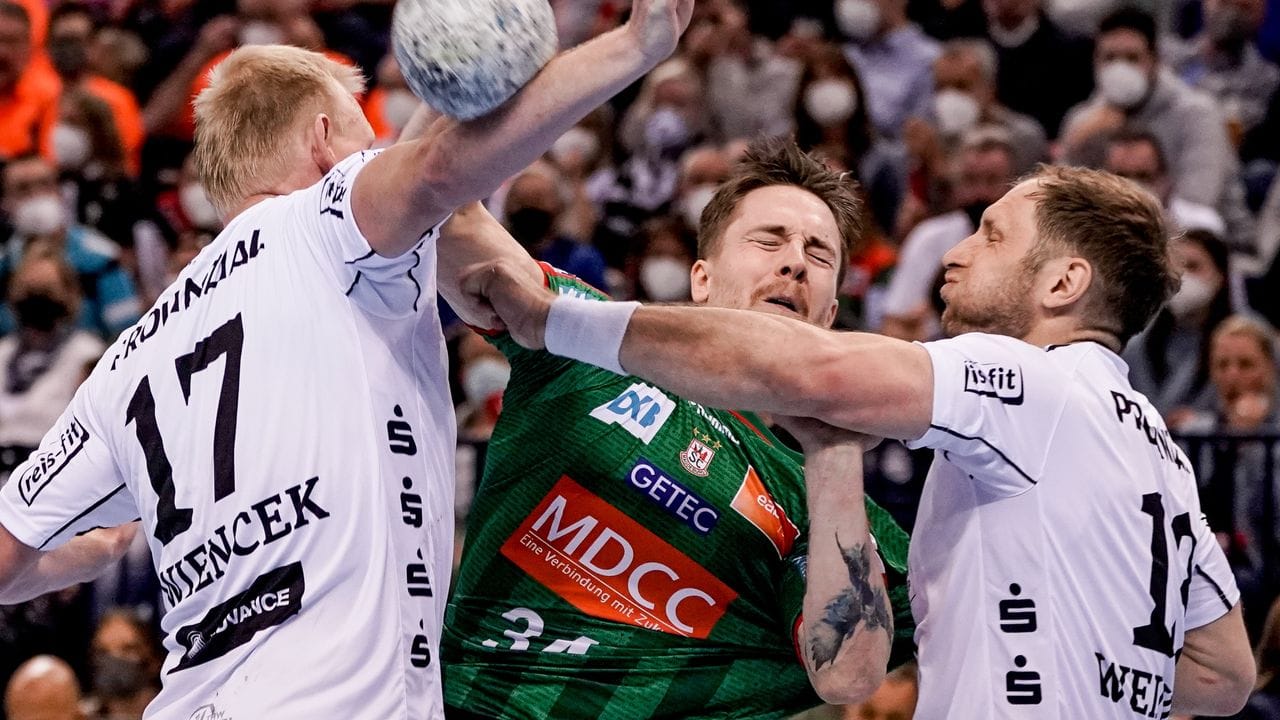 Magdeburgs Michael Damgaard (M) wird von den Kielern Patrick Wiencek (l) und Steffen Weinhold am Wurf gehindert. Magdeburgs Michael Damgaard (M) wird von den Kielern Patrick Wiencek (l) und Steffen Weinhold am Wurf gehindert.