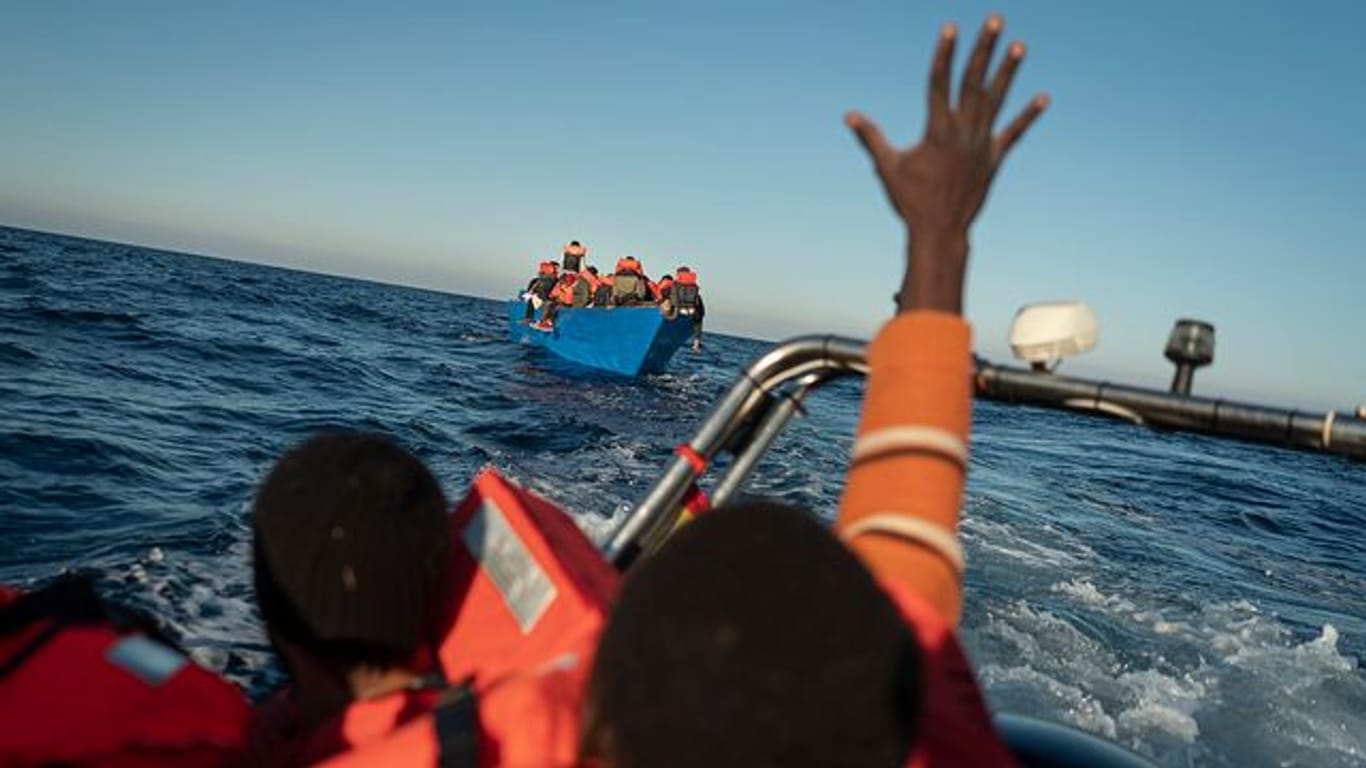 Migranten und Flüchtlinge treiben auf einem überfüllten Holzboot im Mittelmeer (Symbolbild).