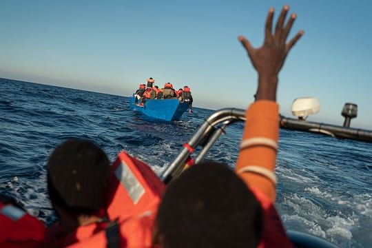 Migranten und Flüchtlinge treiben auf einem überfüllten Holzboot im Mittelmeer (Symbolbild).